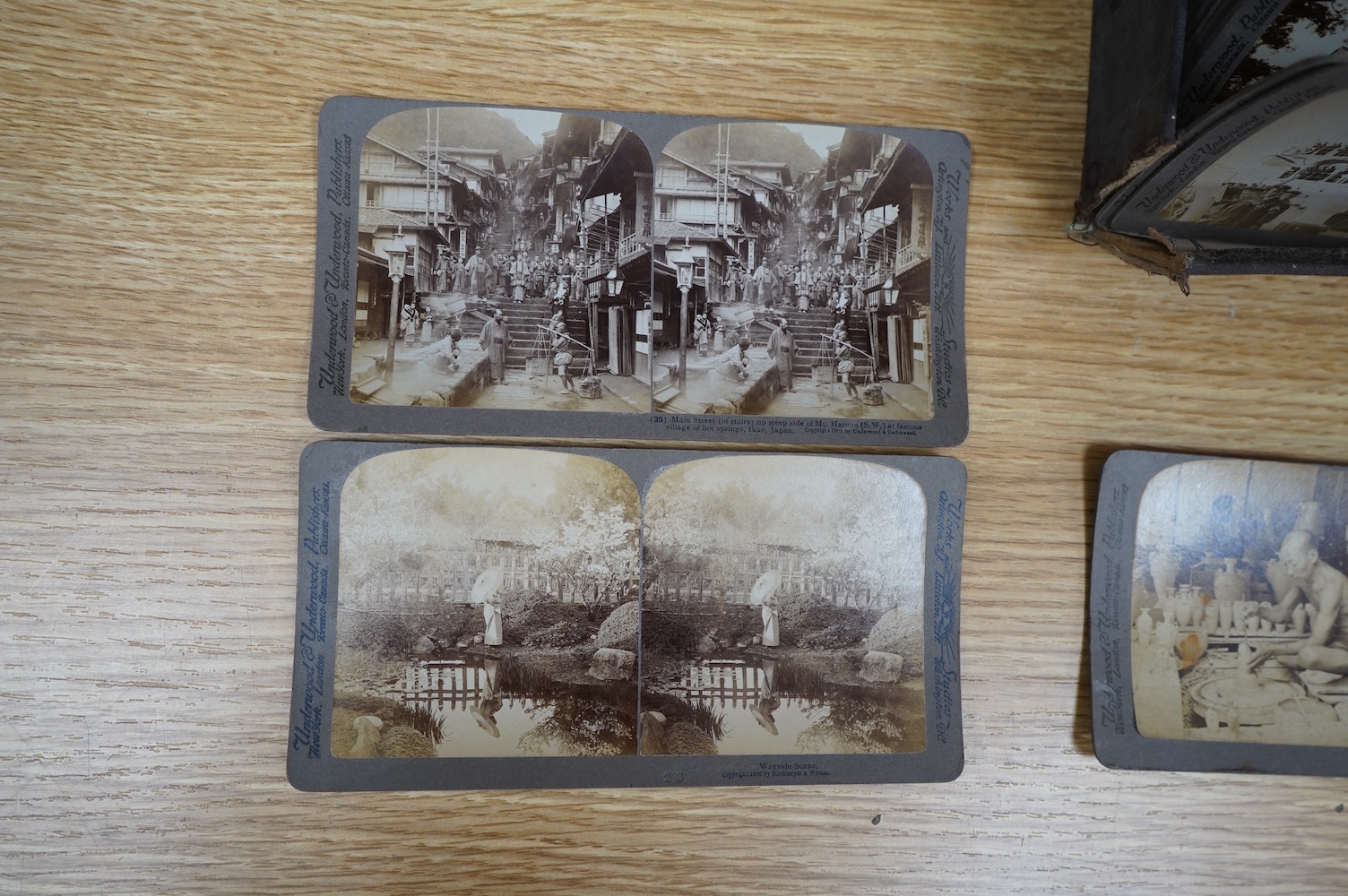 A hand held stereoscopic viewer with a selection of cards of Japanese scenes. Condition - fair.